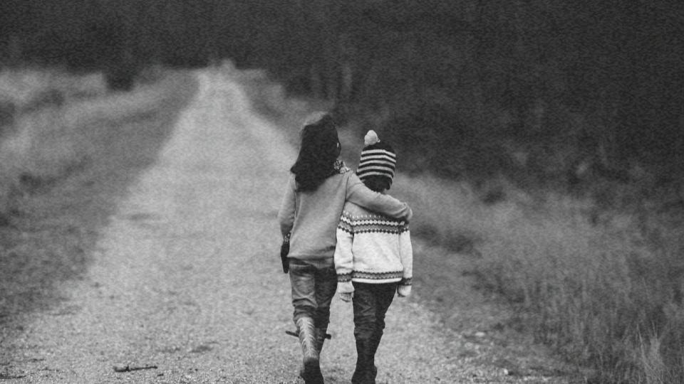 Imagem de duas crianças abraçadas andando de costas representando como surgiram os direitos das crianças e dos adolescentes