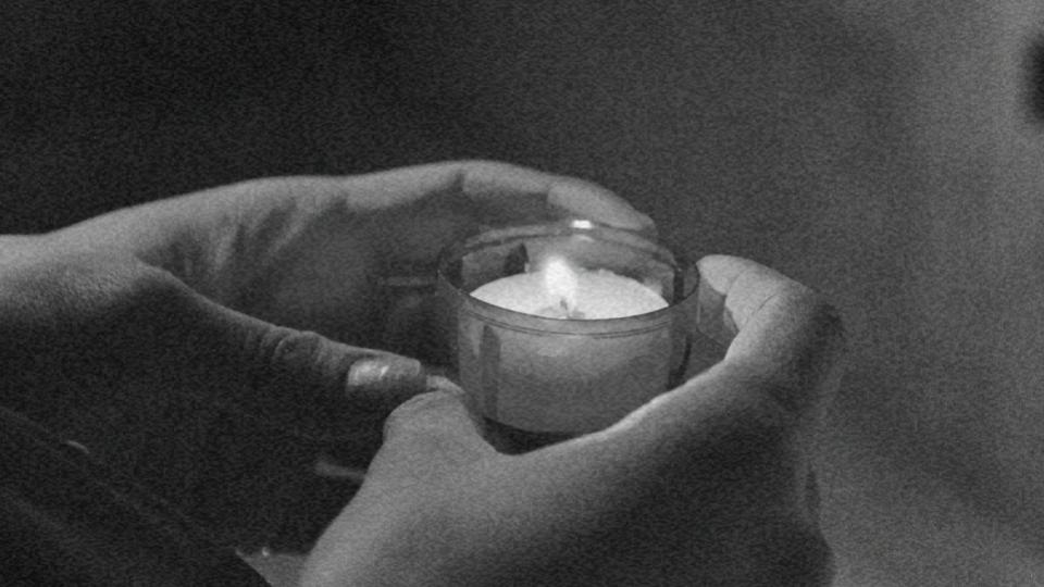 Imagem das mãos de uma pessoa segurando uma vela representando a liberdade religiosa