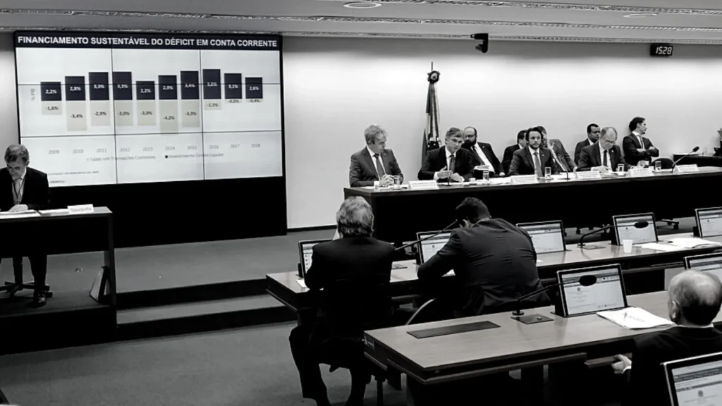 Imagem em preto e branco de uma Comissão Mista de Planos, Orçamentos Públicos e Fiscalização (CMO) para discussão de financiamento de políticas públicas.
