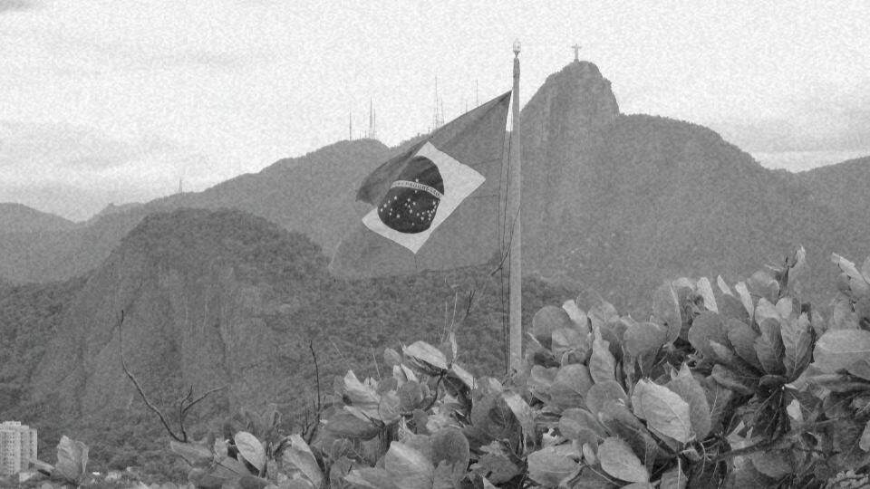 Imagem da bandeira do Brasil e ao fundo o corcovado representando a garantia dos direitos humanos no Brasil