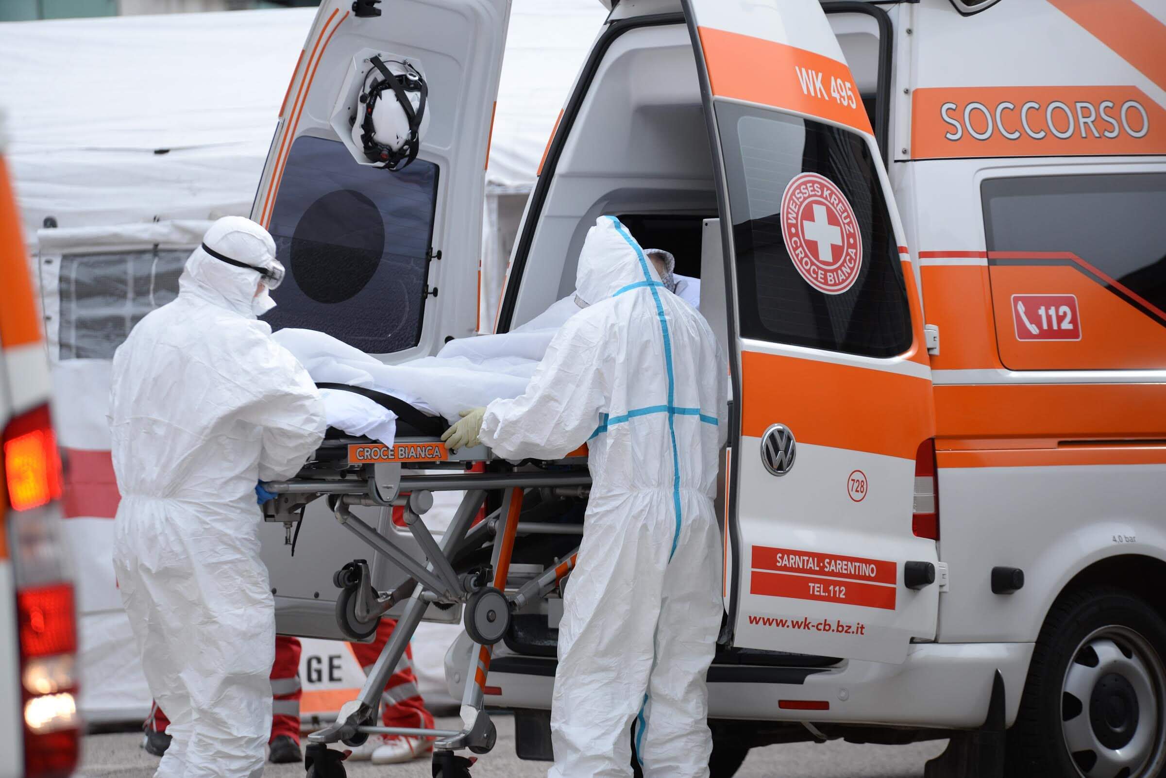 Na imagem, socorristas carregando maca para ambulância na Itália. Conteúdo "sistema de saúde na Itália"