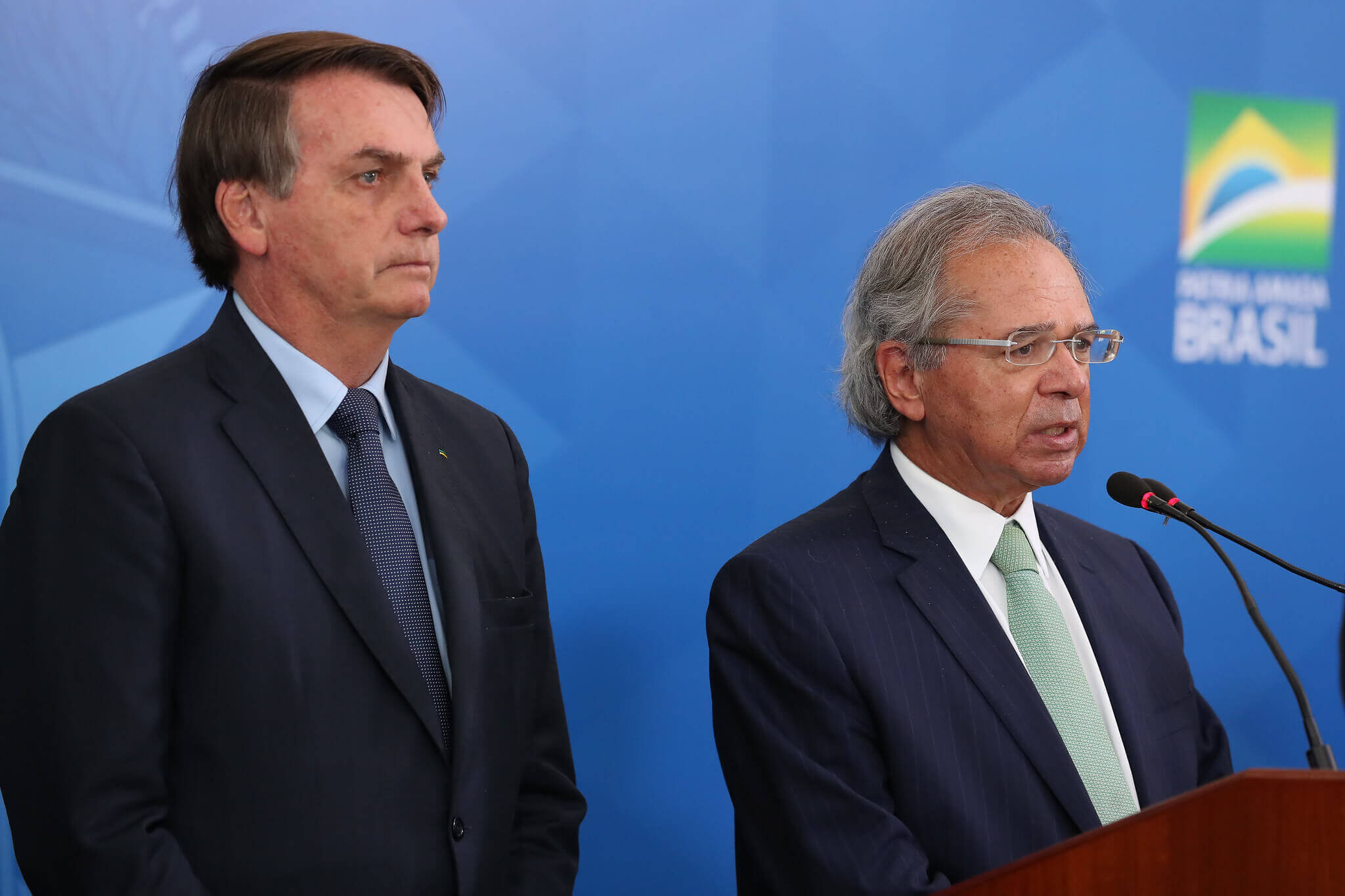 Bolsonaro e Guedes em pé durante coletiva de imprensa. Conteúdo sobre o Ministério da Economia