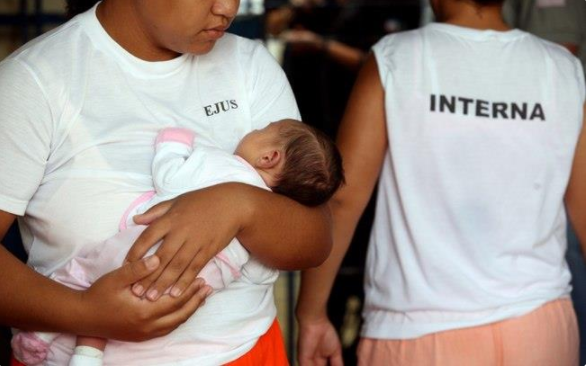 Duas mulheres com uniforme de detentas, uma delas segurando um bebê. Foto: Divulgação/Agência CNJ