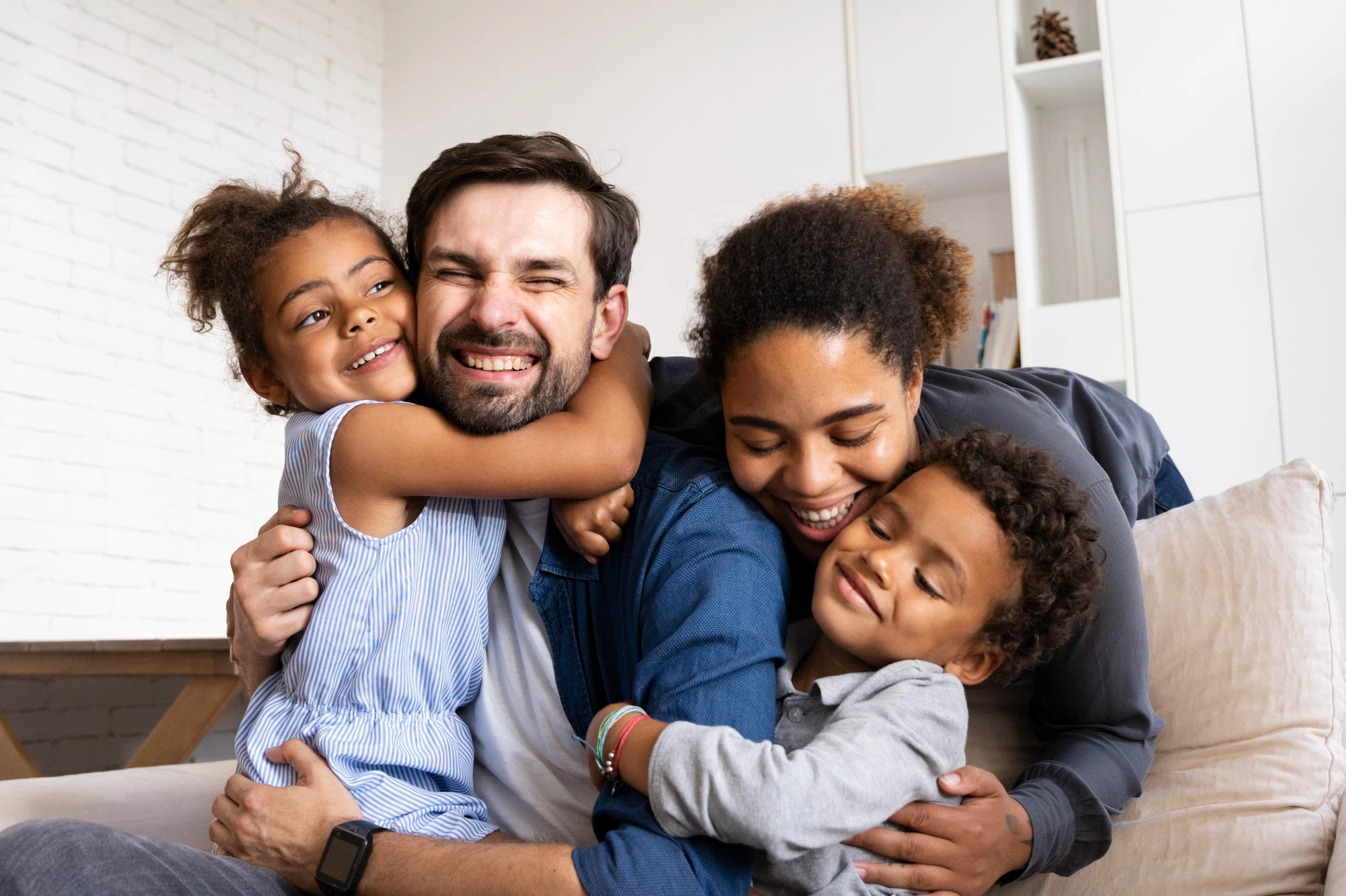 Foto colorida de uma família: pai, mãe, filho e filha pequenos. Ilustra o planejamento familiar.