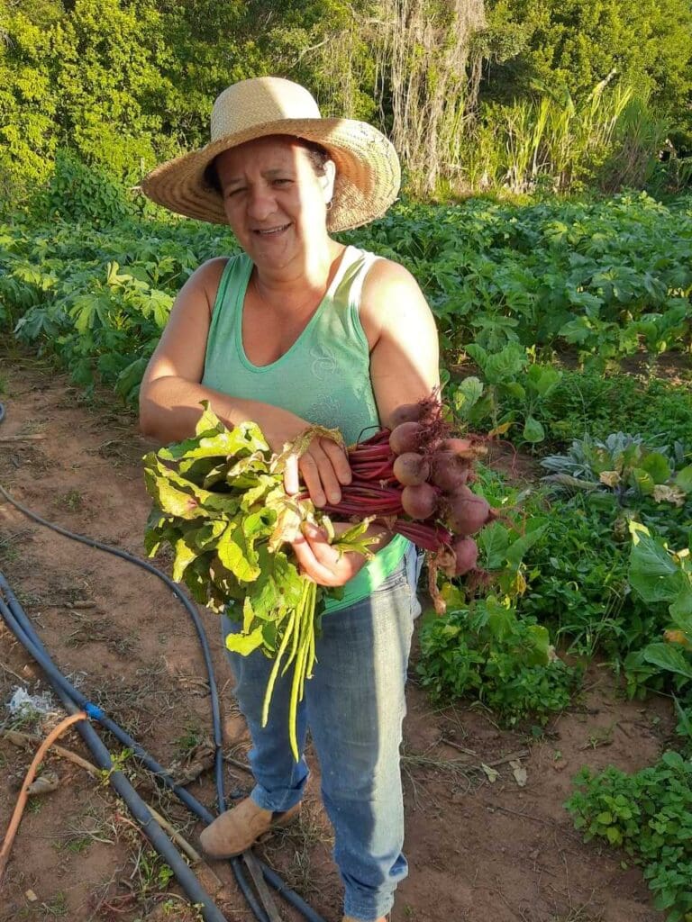 Mulher em plantação segurando rabanetes