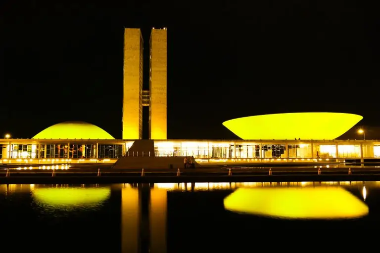 Congresso Nacional iluminado de amarelo.