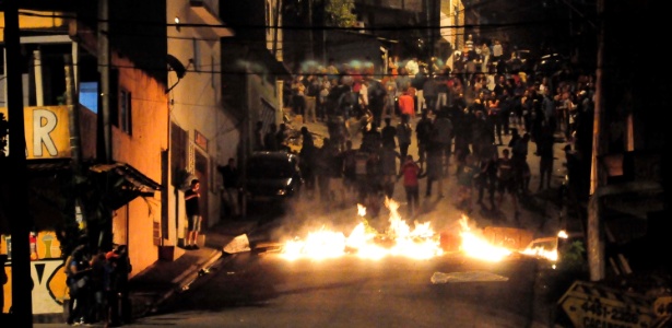 Foto retrata um protesto com um incêndio