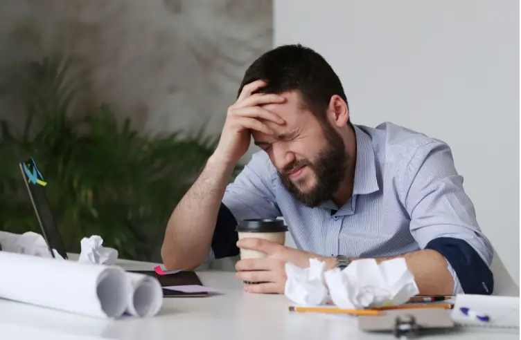 Imagem de um homem cansado. Texto sobre a alienação do trabalhador.