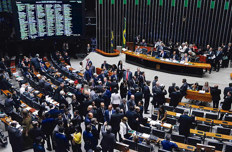 Câmara dos Deputados vista de cima. Texto sobre coalizões partidárias.