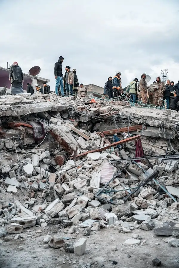 Pessoas andando em cima de escombros após terremoto.