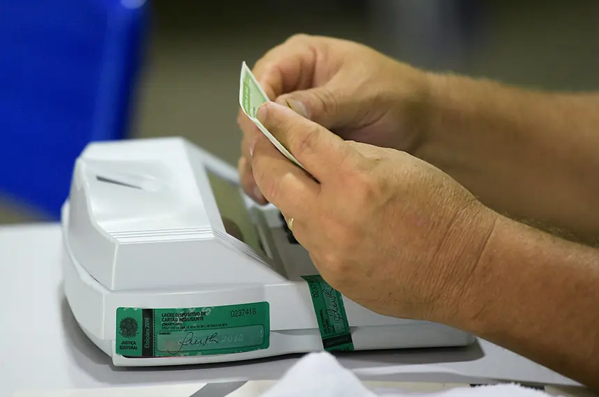 Imagem de um mesário checando título de eleitor