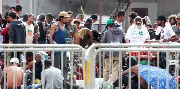 Imagem apresentando a localização da Cracolância, com foco nas grades colocadas para separar os frequentadores. Há pessoas em pé e sentadas, em condição de aglomeração.