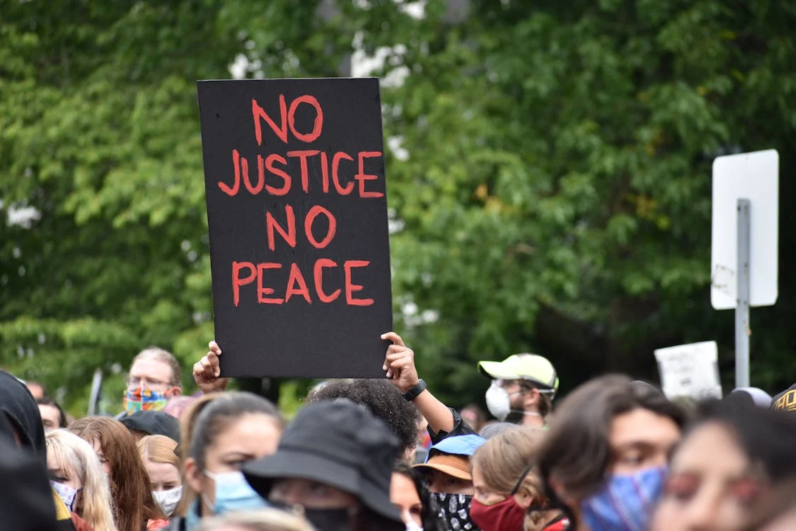 Pessoa em protesto com cartaz "no justice, no peace", defendendo a ideia de que sem justiça não há como construir uma cultura de paz.