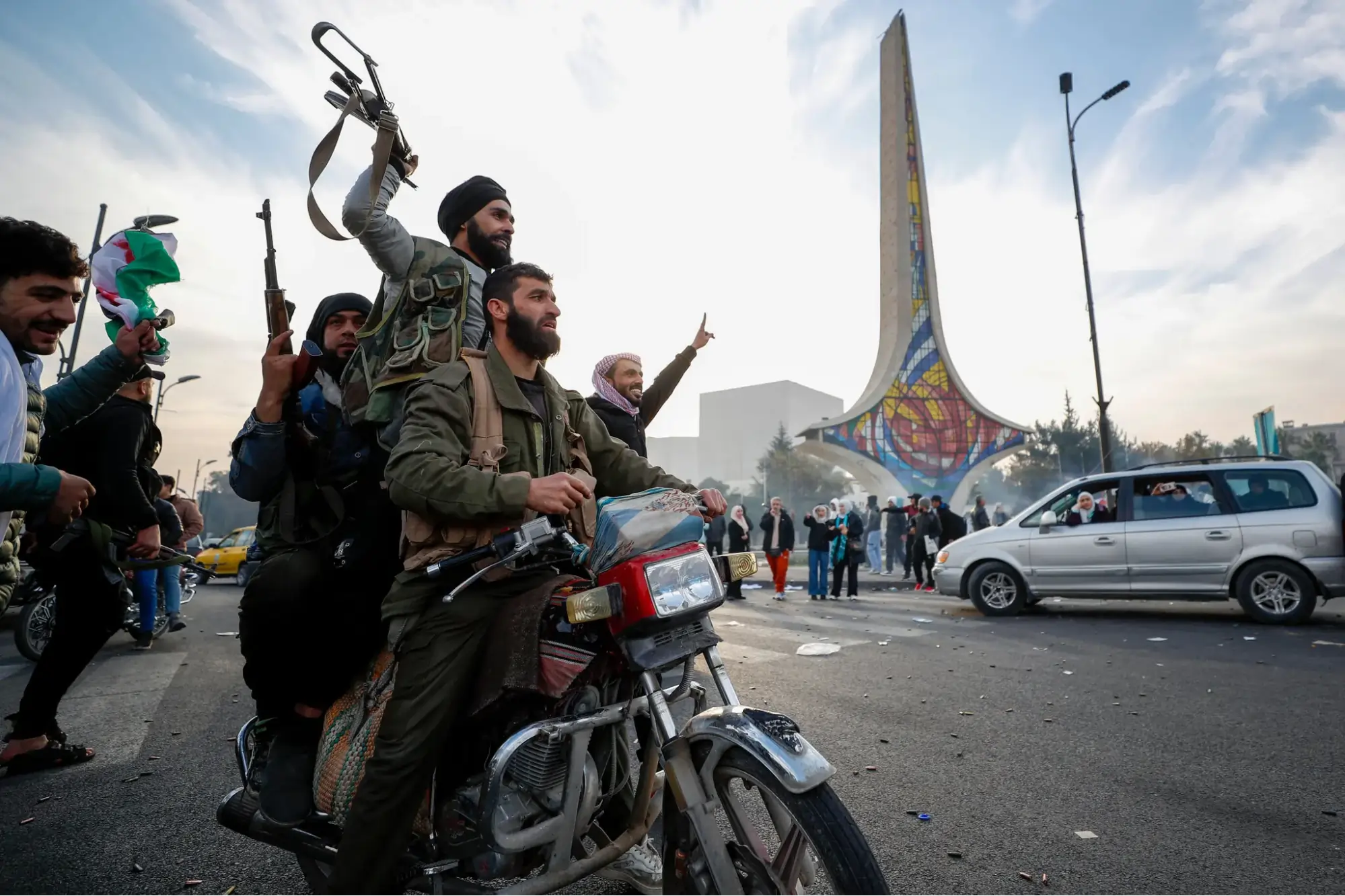 Fotografia de combates da oposição sírias comemorando a queda do governo em Damasco.