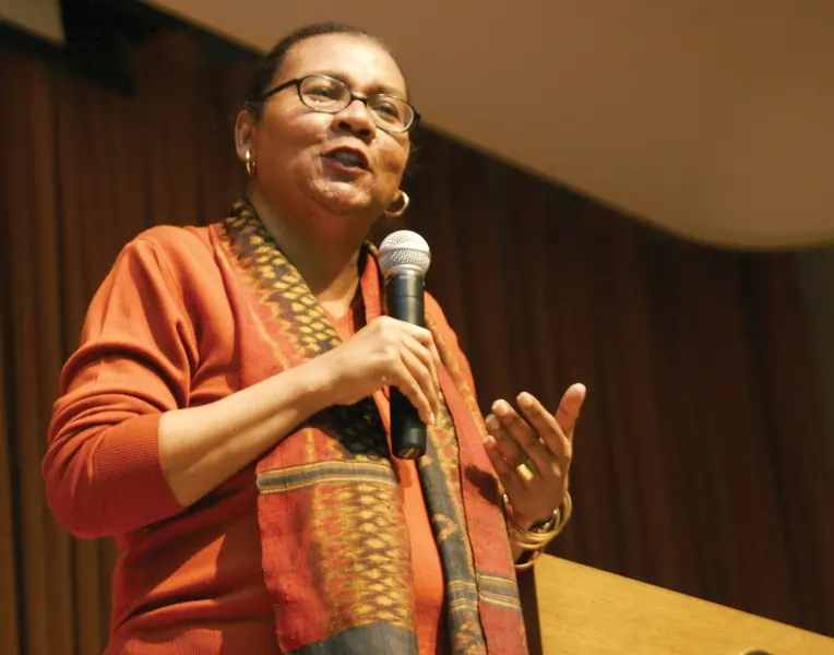 bell hooks segurando um microfone em uma palestra. Texto: A disputa entre progressistas e conservadores na educação brasileira