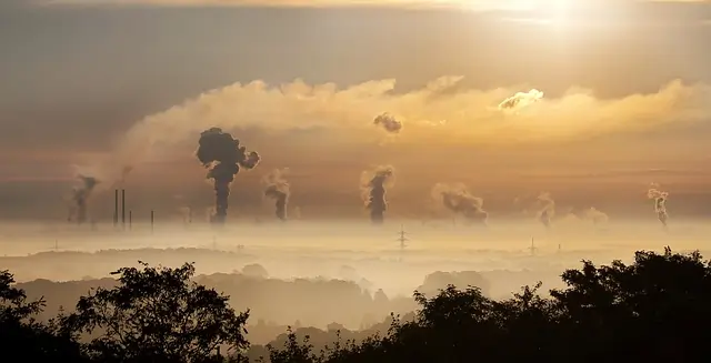 Imagem de um nascer do sol com muitos focos de fumação ao fundo, indicando grande concentração de indústrias e das ilhas de calor.