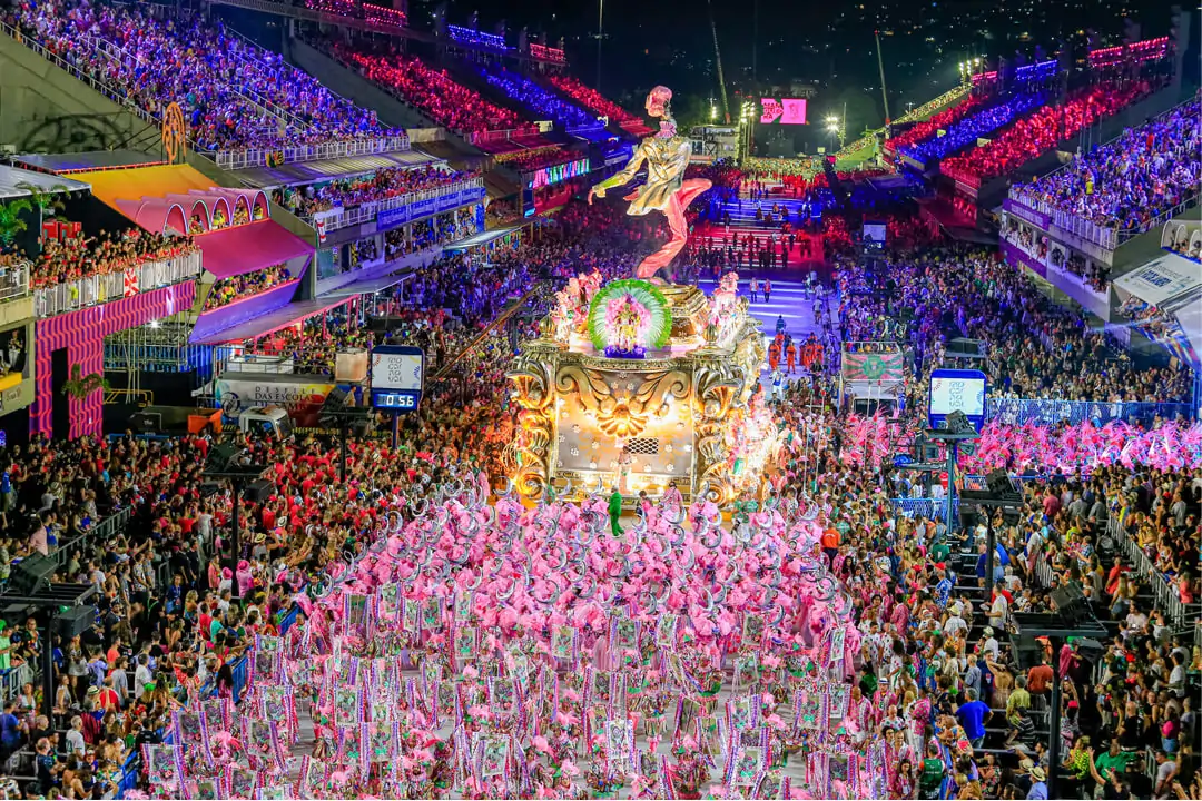 Imagem de uma escola de samba desfilando no sambódromo do Rio de Janeiro. Texto: Tipos de carnaval no Brasil